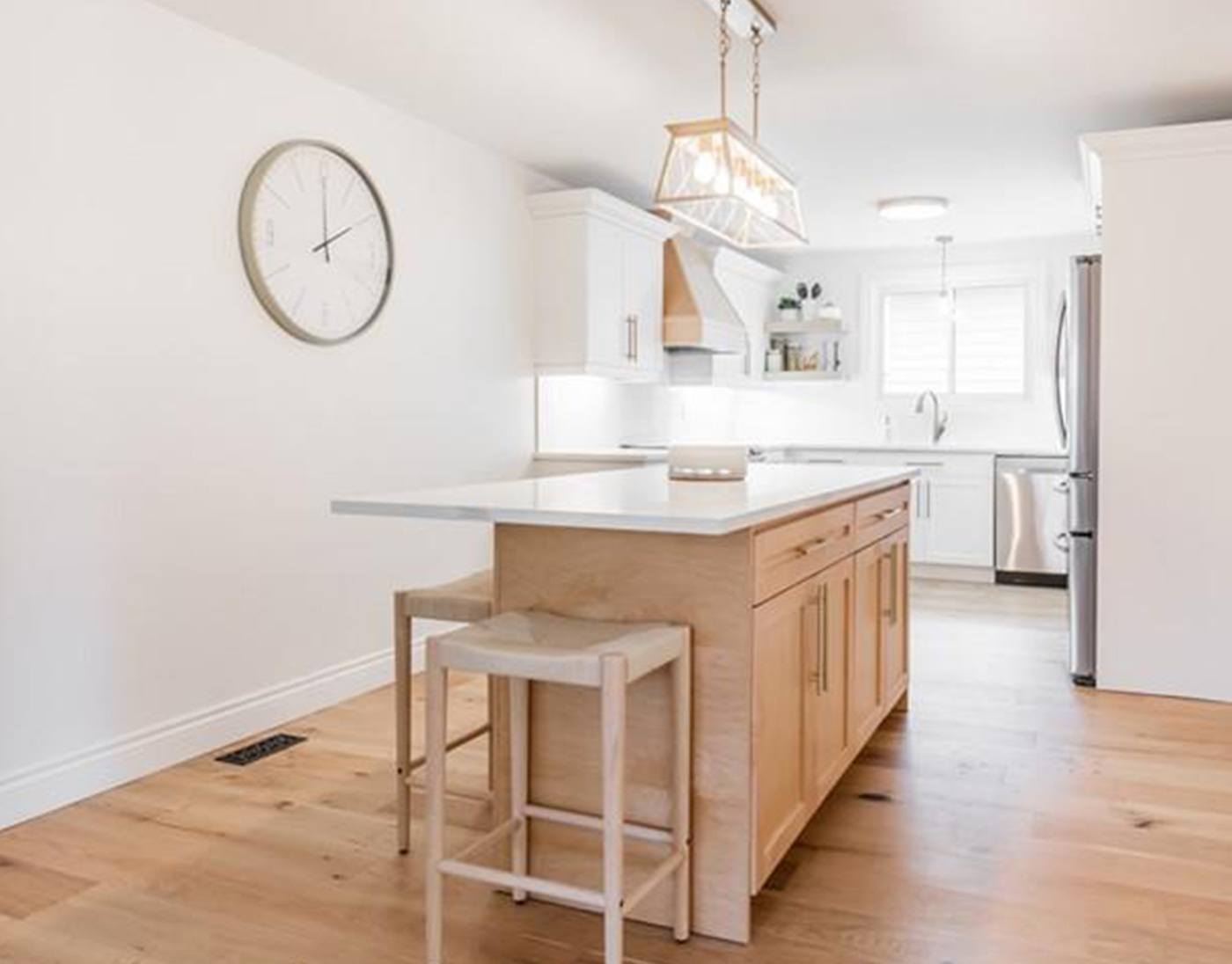 LIV4 Homes kitchen renovation with a natural wood island, white cabinetry and gold lighting